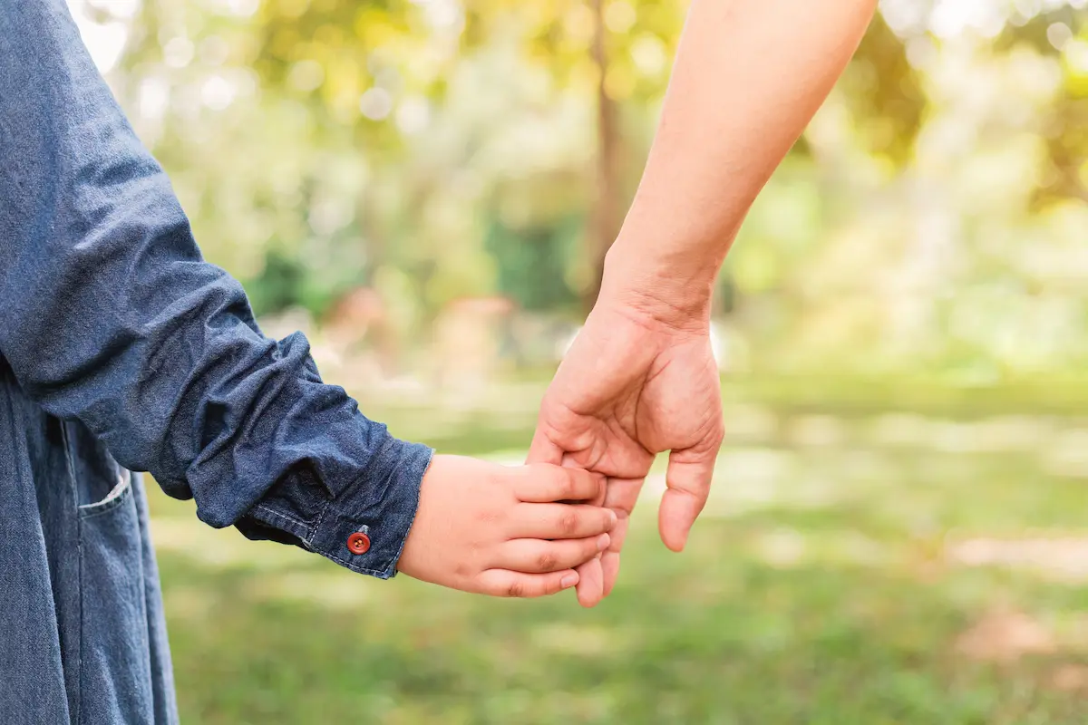 adult and child holding hands