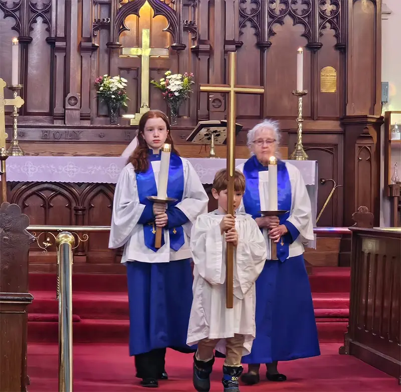 a person who carries the processional cross at the front of a church service